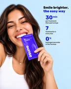 Smiling woman holding a purple Asuno V34 Color-correcting Strips sachet: 30 minutes per treatment, 7 treatments per box, no hydrogen peroxide